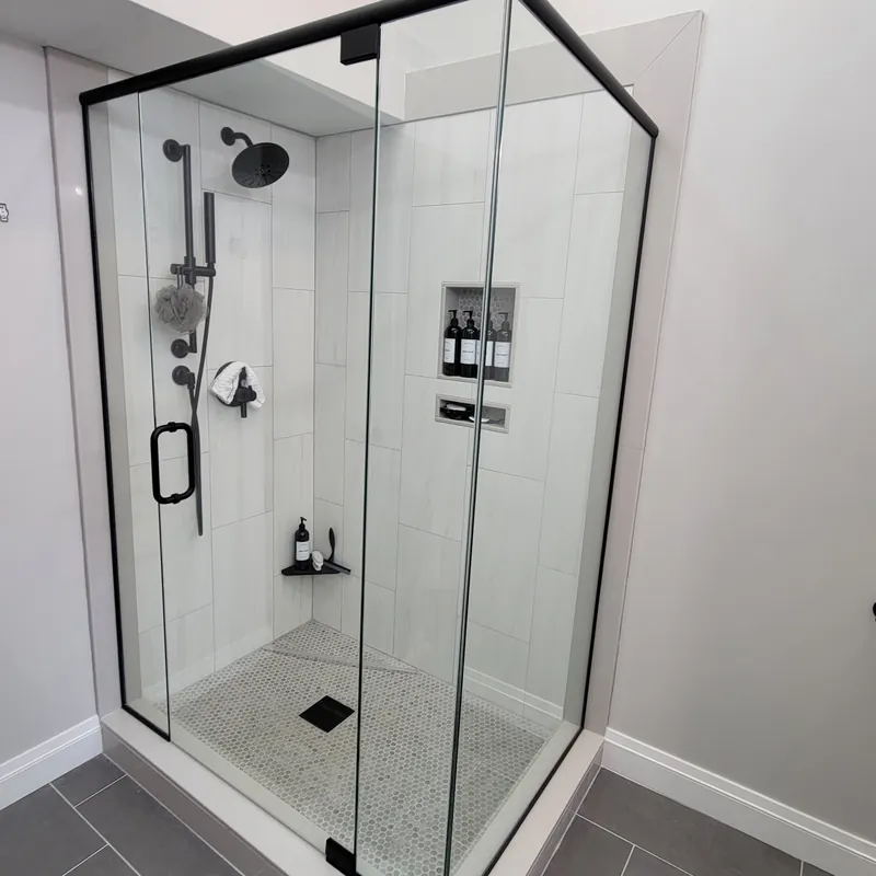 A corner shower enclosure in a slim matte black frame
